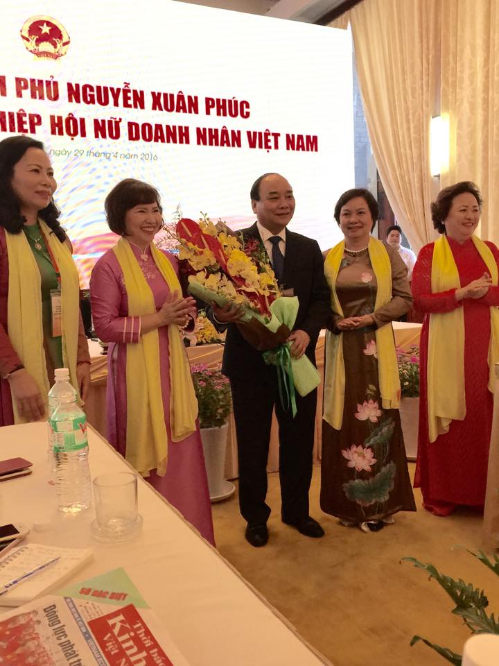 Thứ trưởng Bộ Công Thương Hồ Thị Kim Thoa, Chủ tịch Hiệp hội Nữ doanh nhân VN tặng hoa cho Thủ tướng Nguyễn Xuân Phúc nhân buổi gặp mặt.