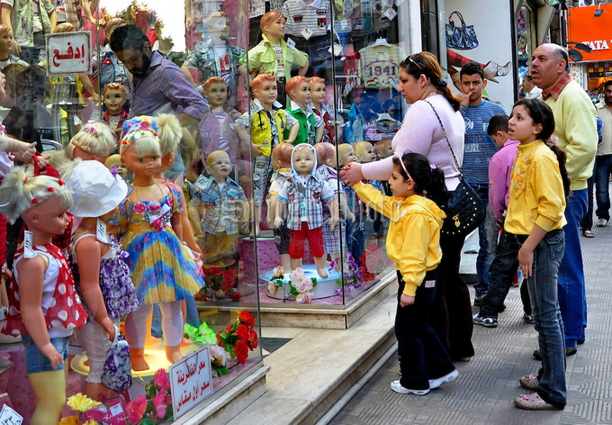Egypt, Cairo: April 12, An Egyptians children stand with their parents in front of toys shop, as they shopping in the Fouad street in Cairo. Egypt on 12 April 2011. ( Photo by Ahmed Gomaa/ Sniper Photo)