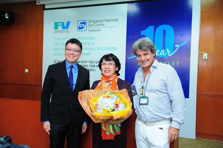 Bệnh nhân Nguyễn Thị Thanh Phương ở TPHCM, người được BS Edmund Wong điều trị thành công bệnh lý về võng mạc tại SNEC, nhận hoa chúc mừng từ BS Edmund Wong (trái) và BS Jean-Marcel Guillon, TGĐ bệnh viện FV.