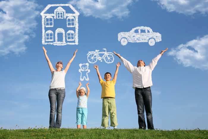 Family of four on grass with hands up and dream