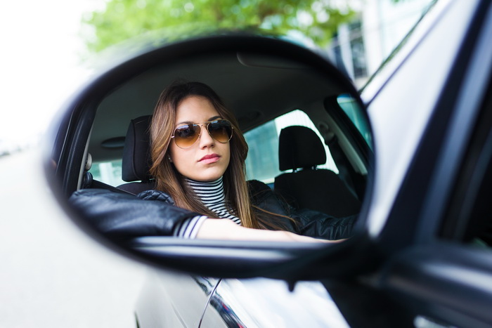 Portrait of beautiful young woman driving her car.