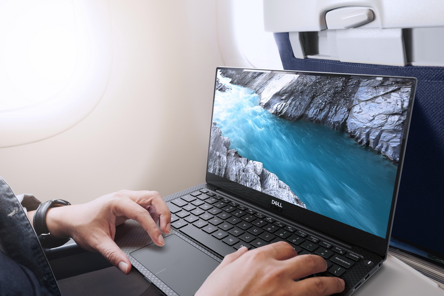 Person seated on an airplane using a Dell XPS 13 (Model 9370) touch notebook computer, codename Italia.